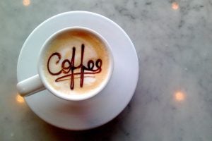 A coffee mug with caramel inside the spells "coffee". 