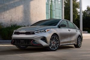 Gray 2022 Kia Forte parked in front of a modern home.