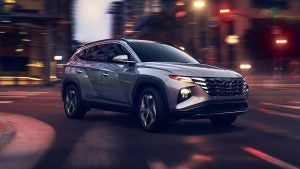 Grey 2022 Hyundai Tucson on the road at night turning the corner.