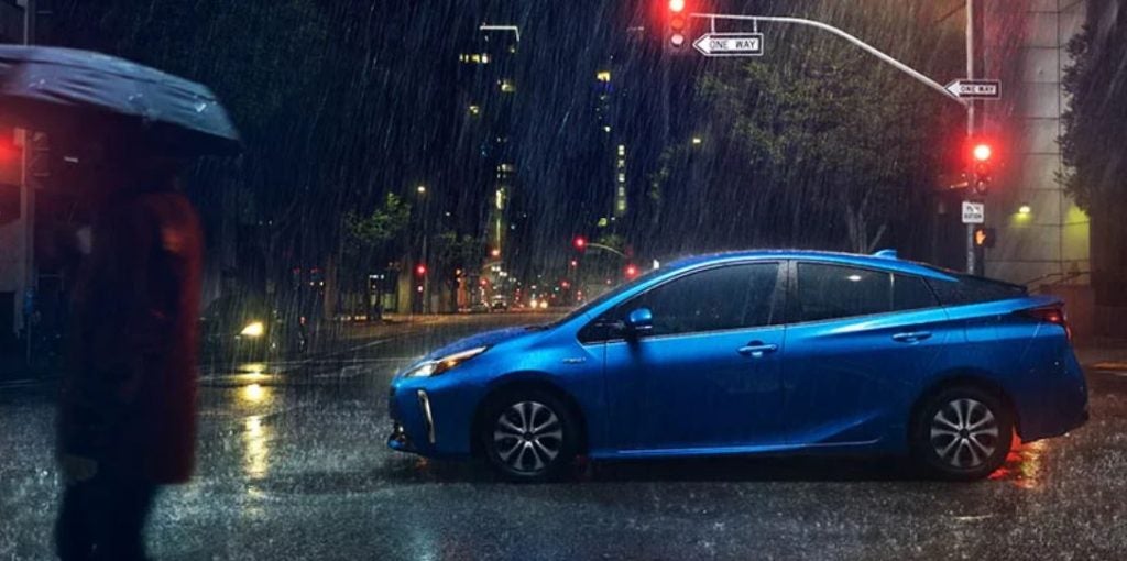 A blue 2022 Prius driving in the rain.