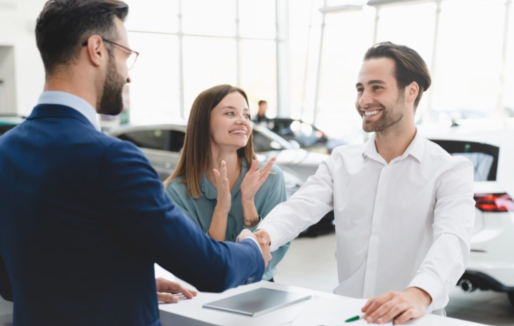 A couple buying a car at a dealership.