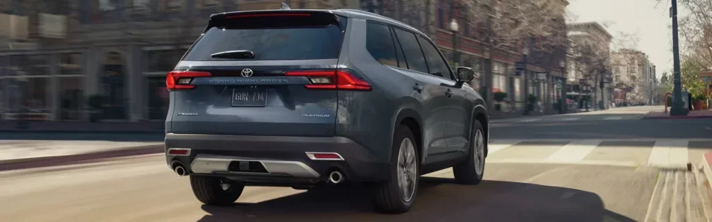 Toyota Grand Highlander SUV driving through a city street in motion.