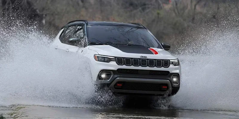 Jeep Compass driving through water, showcasing its off-road capabilities.
