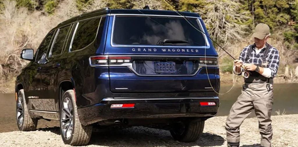 A fisherman getting his line ready by his blue 2022 Jeep Grand Wagoneer.