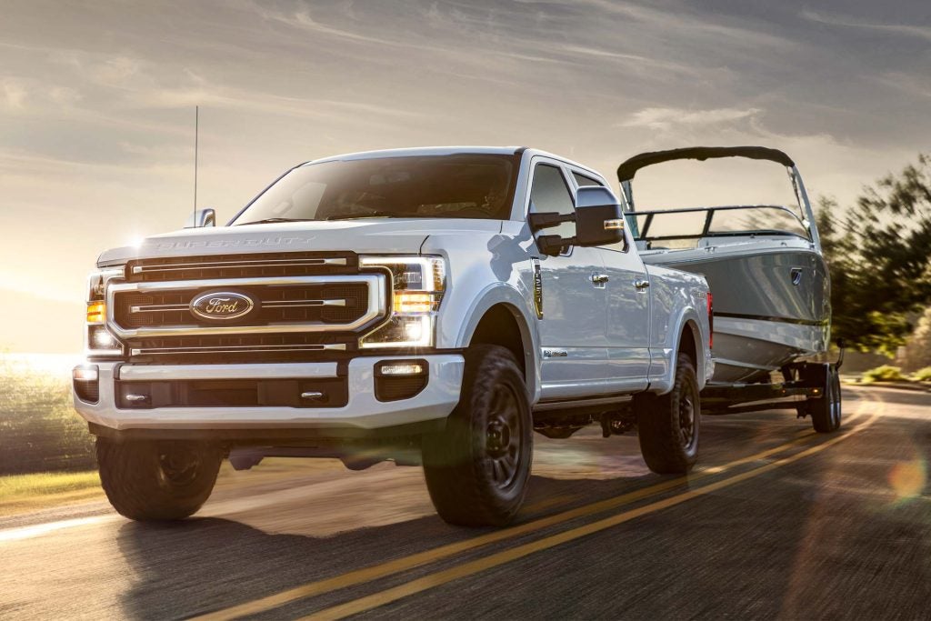A white 2022 Ford F-350 towing a boat.