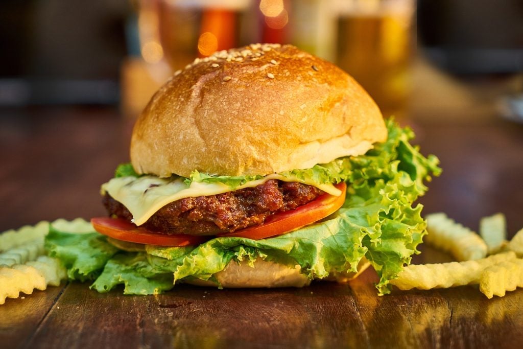 A juicy burger surrounded by fries.