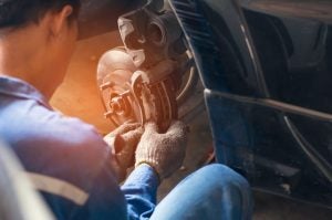An auto technician working on brakes.