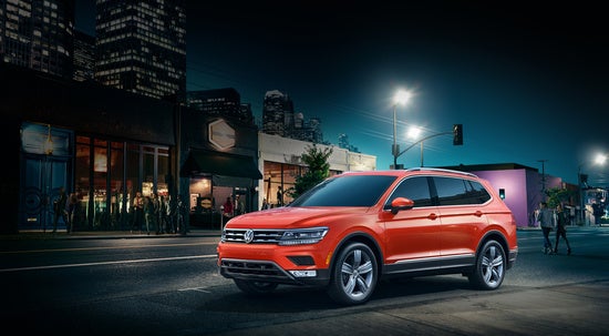 orange volkswagen tiguan parked downtown at night