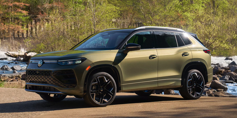 2026 Volkswagen Tiguan parked near a riverside with trees in the background, highlighting its sleek design, alloy wheels, and modern SUV styling.