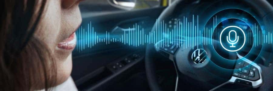 a woman speaks inside a Volkswagen vehicle with a graphic overlay of an audio file depiction