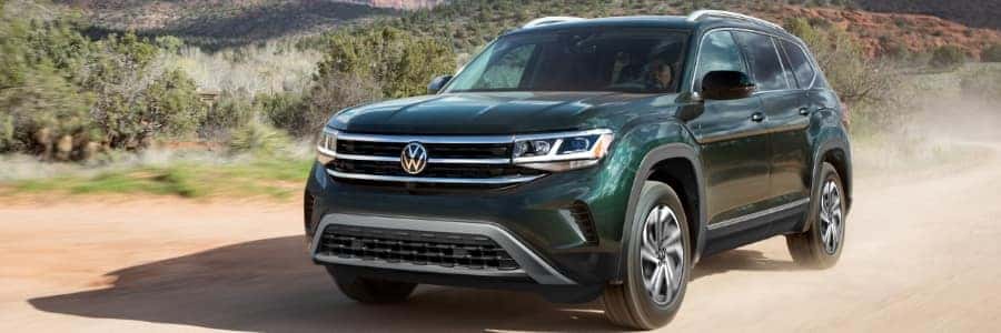 Forest Green VW Atlas drives through desert
