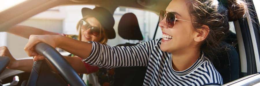 two women driving in a car with the windows down