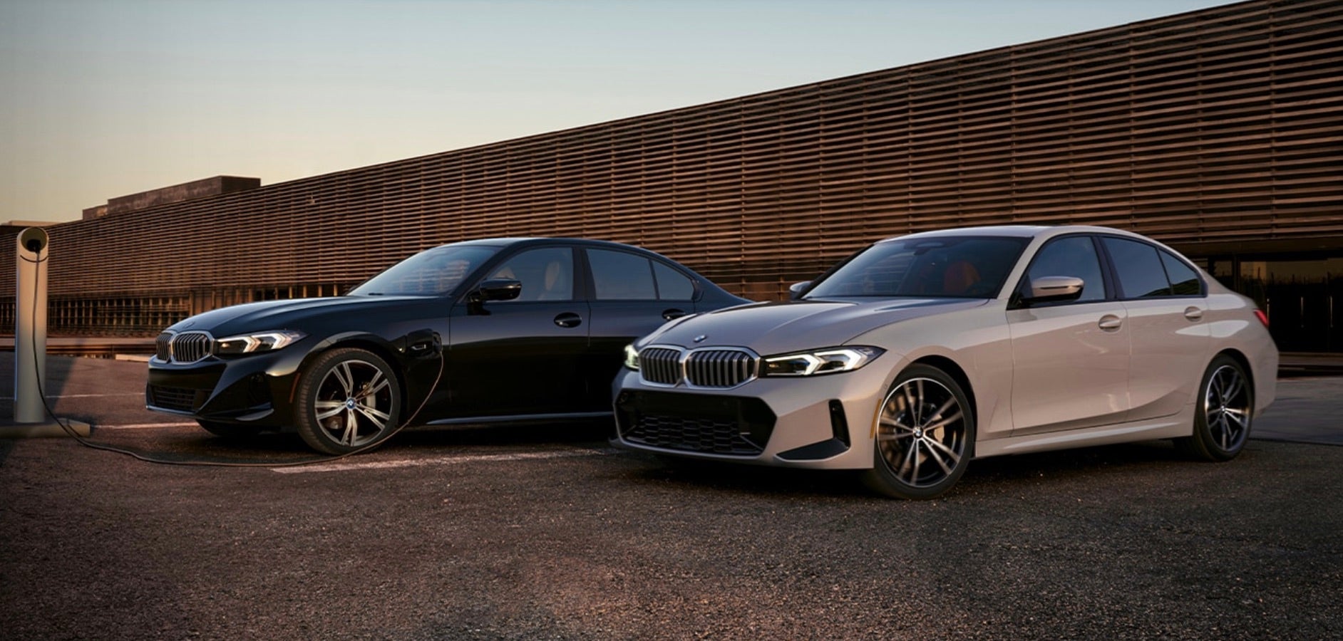 Two 2023 BMW three series parked and charging.