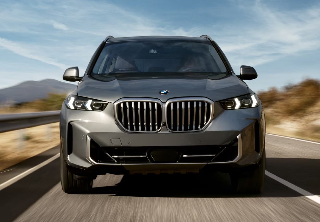 A gray 2025 BMW X5 driving on a road in Rockford, IL.