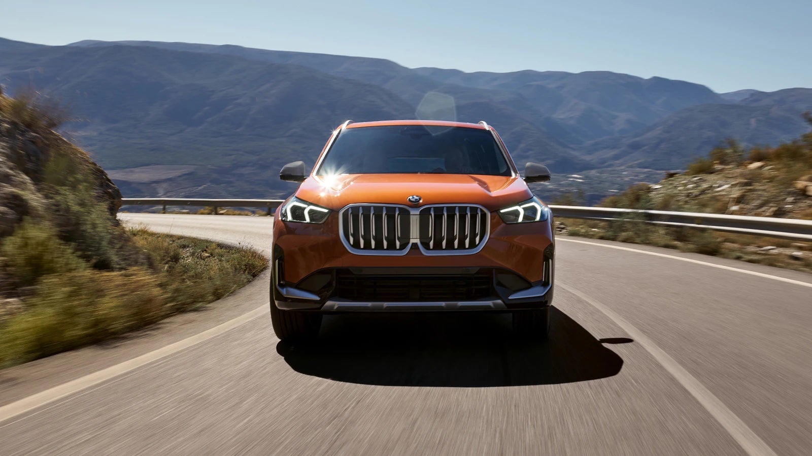 Orange 2023 BMW X1 on the road