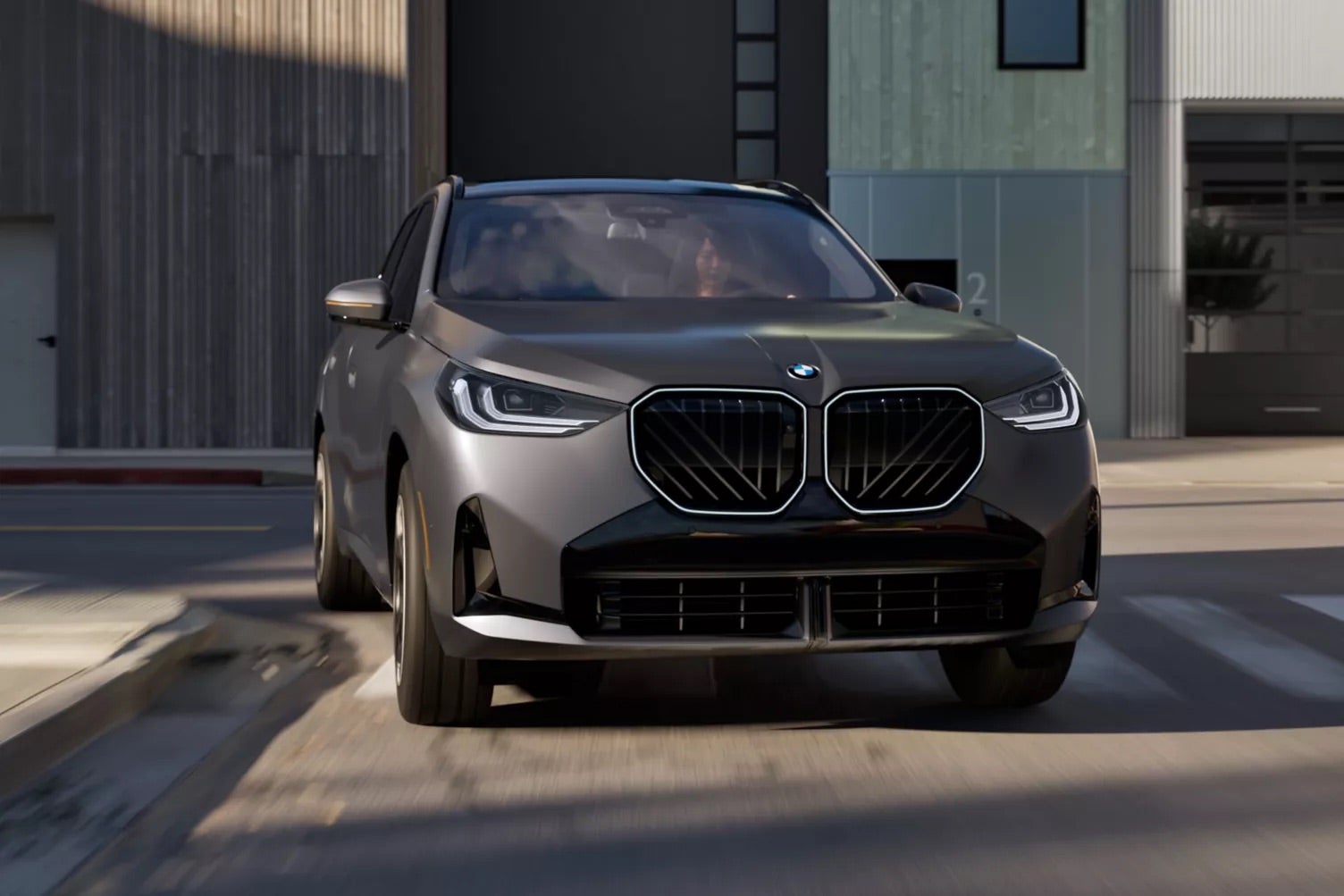 A dark 2026 BMW X3 driving through Rockford, IL