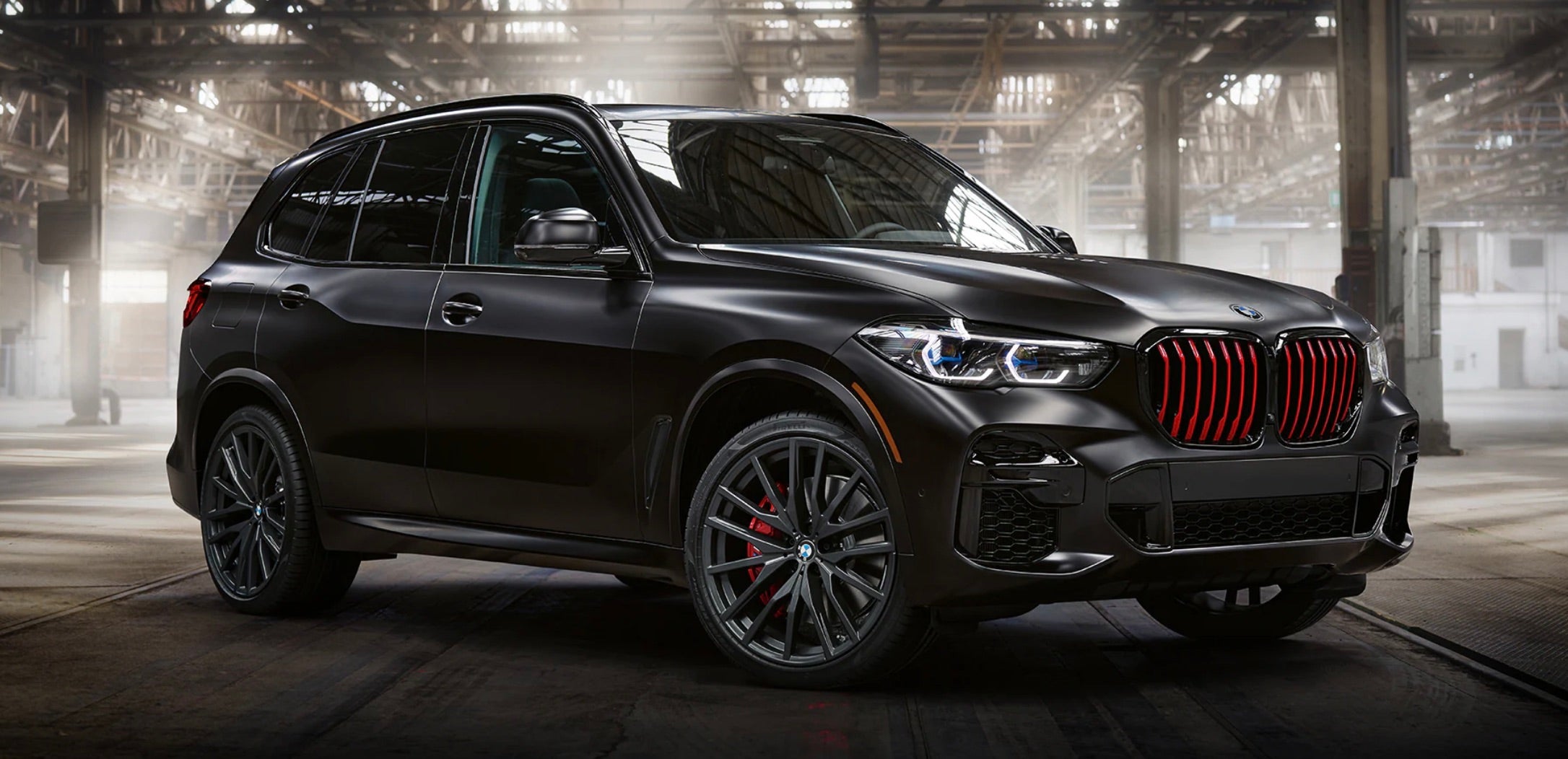 2022 BMW X5 parked inside a shop with wires showing around the vehicle.