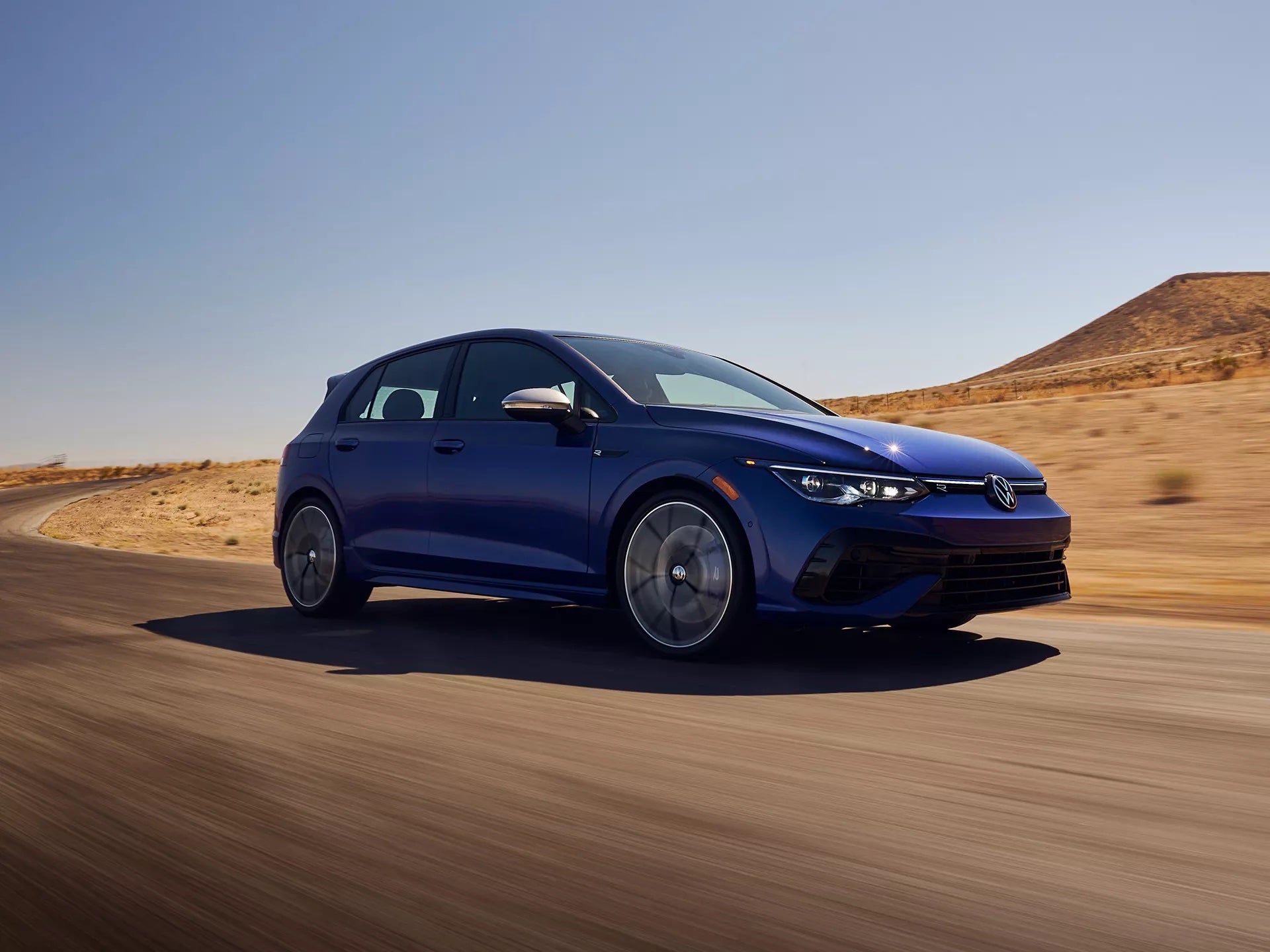 The 2024 Volkswagen Golf R driving through a desert.