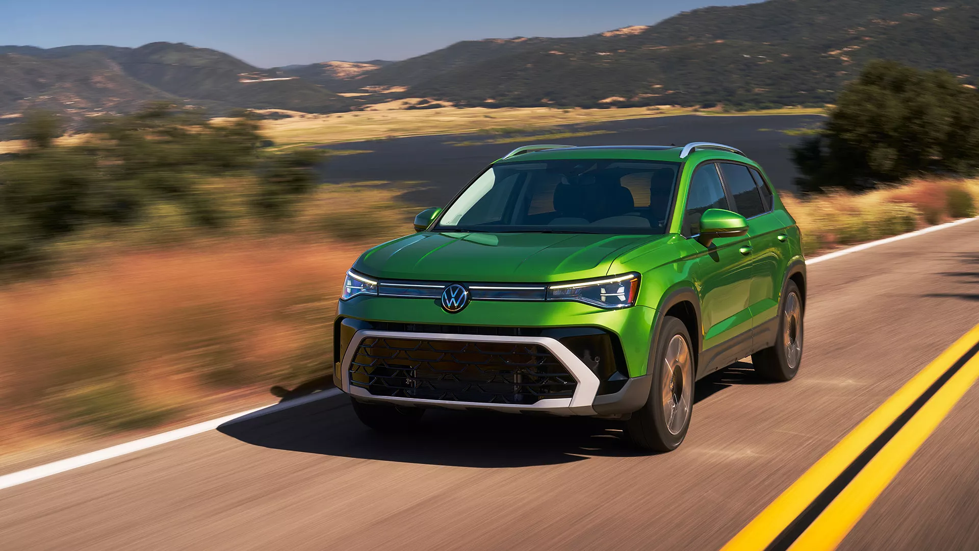 A green 2025 VW Taos driving in Rockford, IL
