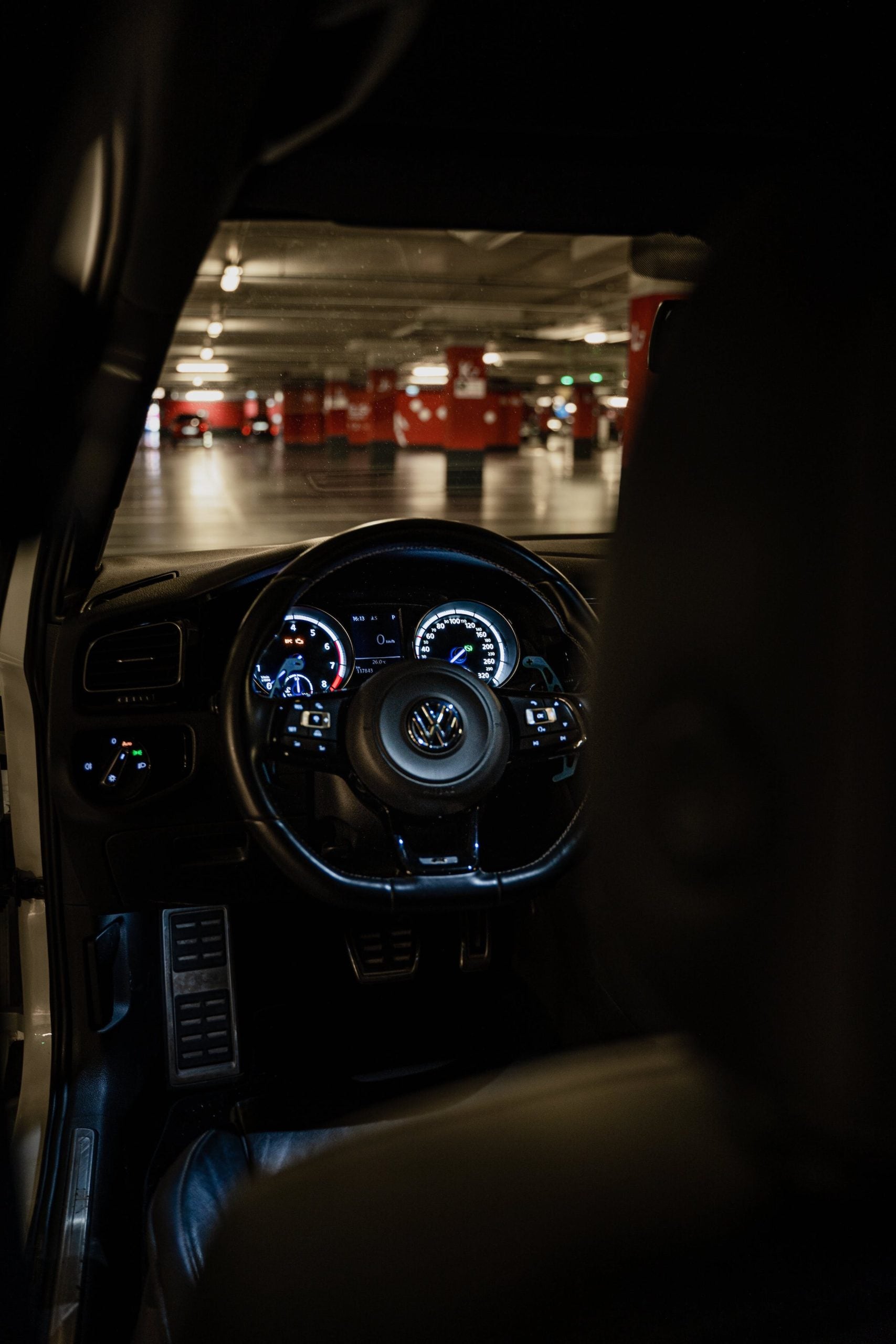 Over the shoulder shot into a Volkswagen looking at the drivers dashboard.