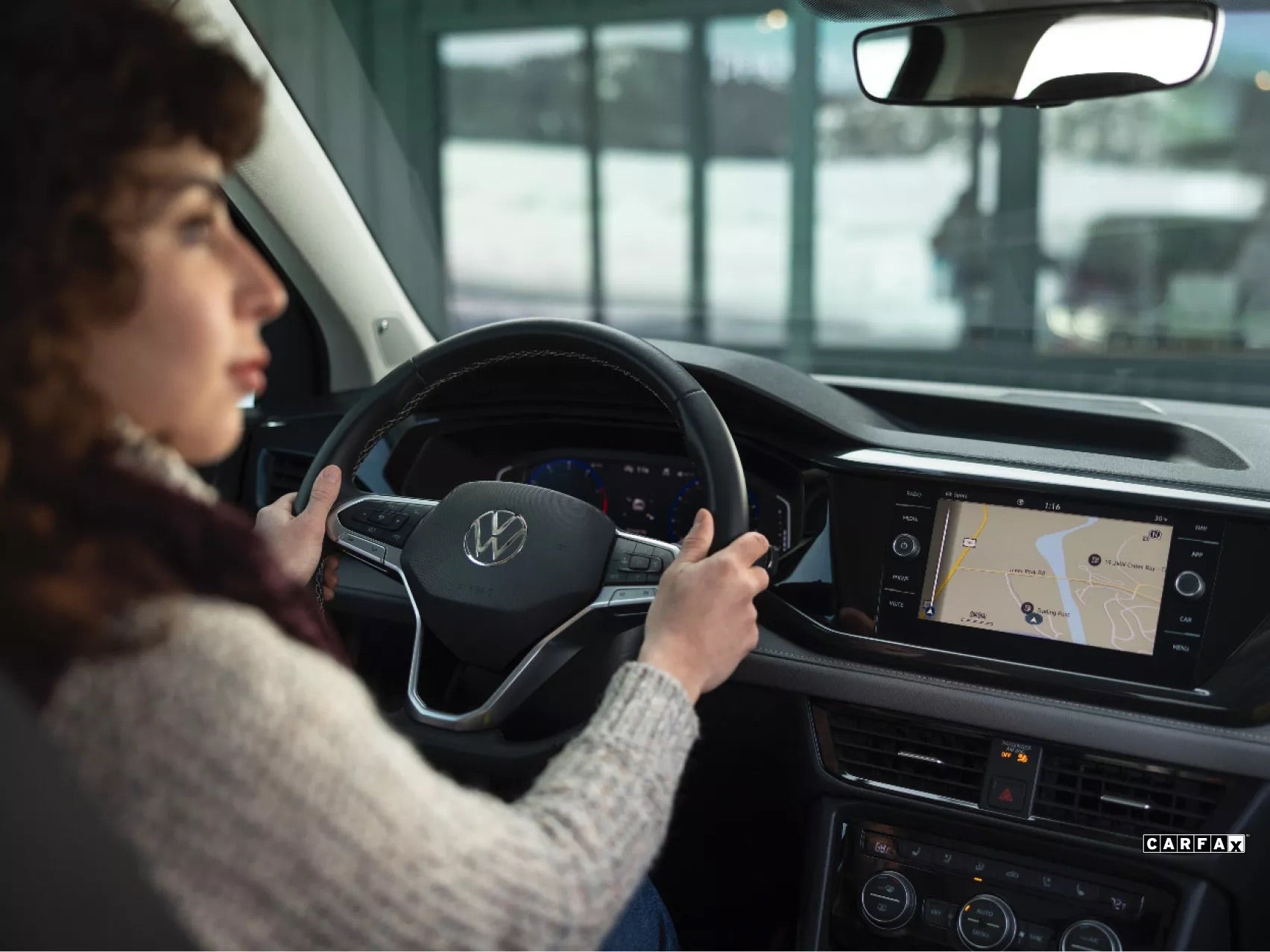 A woman driving a pre-owned Volkswagen from Lou Bachrodt VW