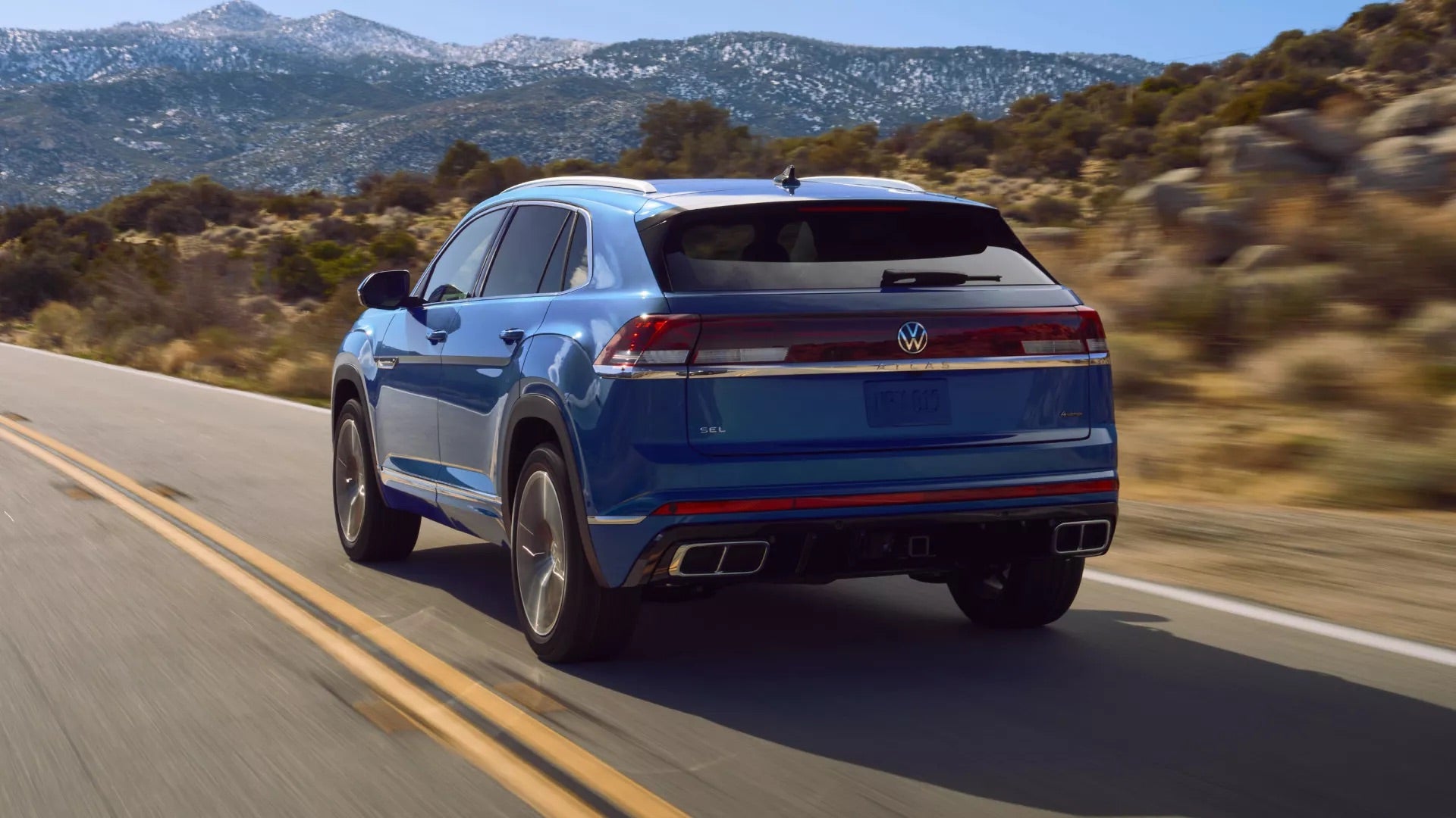 A blue 2026 VW Atlas Cross Sport driving through Rockford, IL