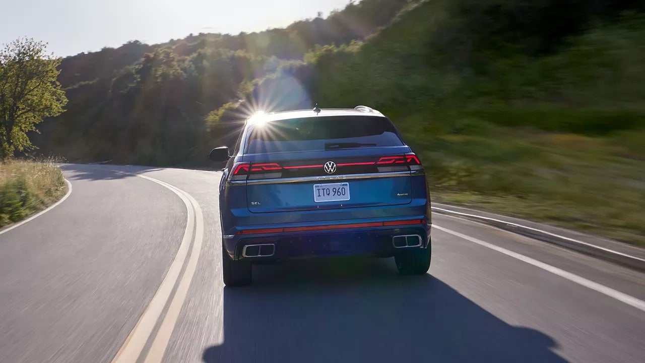 A blue 2025 Volkswagen driving down road in Rockford, IL