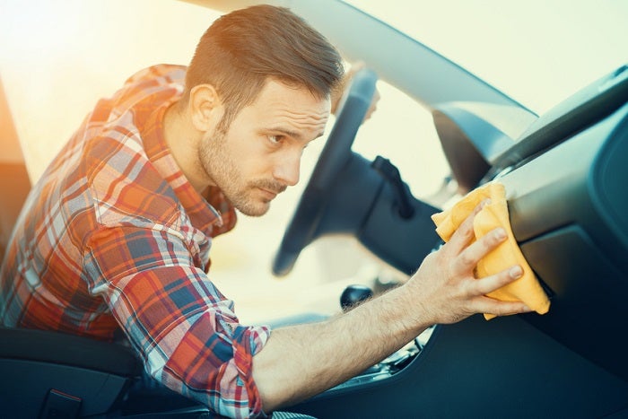 Man cleaning the dashboard of his car