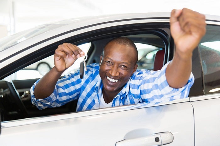 african man showing a car key