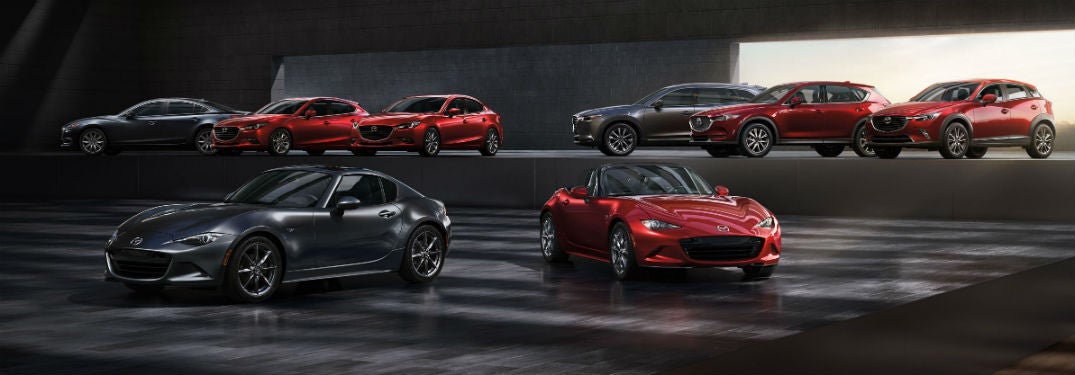 Image of the full lineup of Mazda vehicles parked in a dark room.