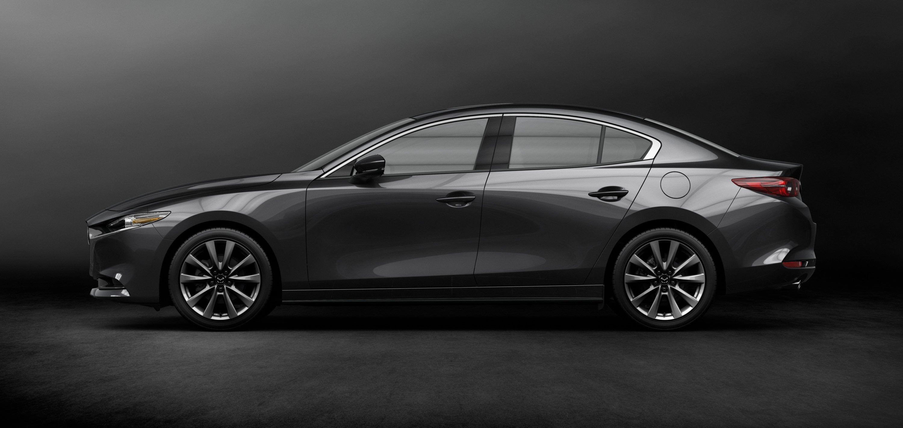 Image of a gray 2019 Mazda3 in a dark room.