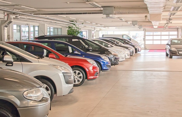 Many cars in parking lot or garage.
