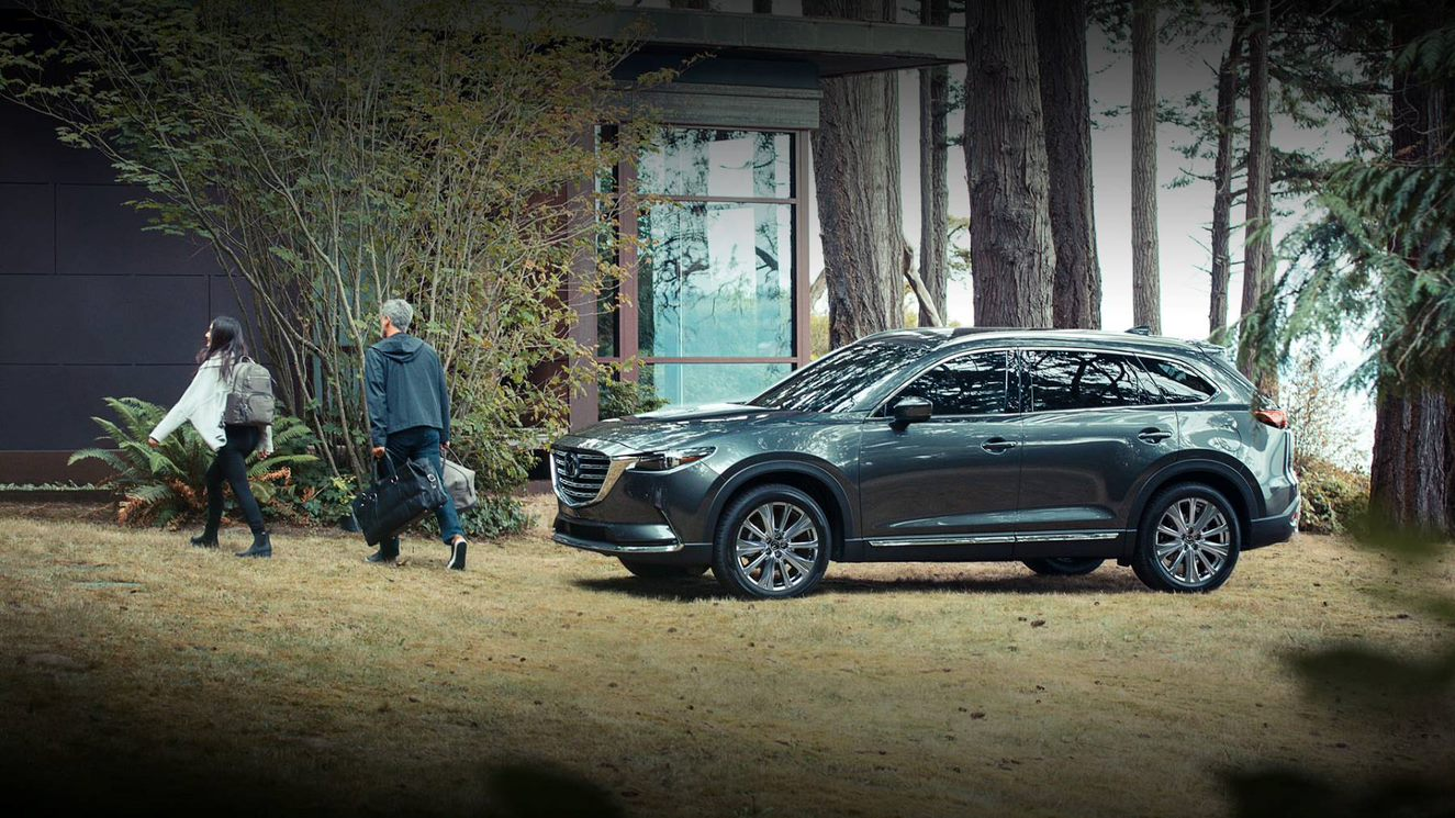 A teenager and her father exiting the 2023 Mazda CX-9.