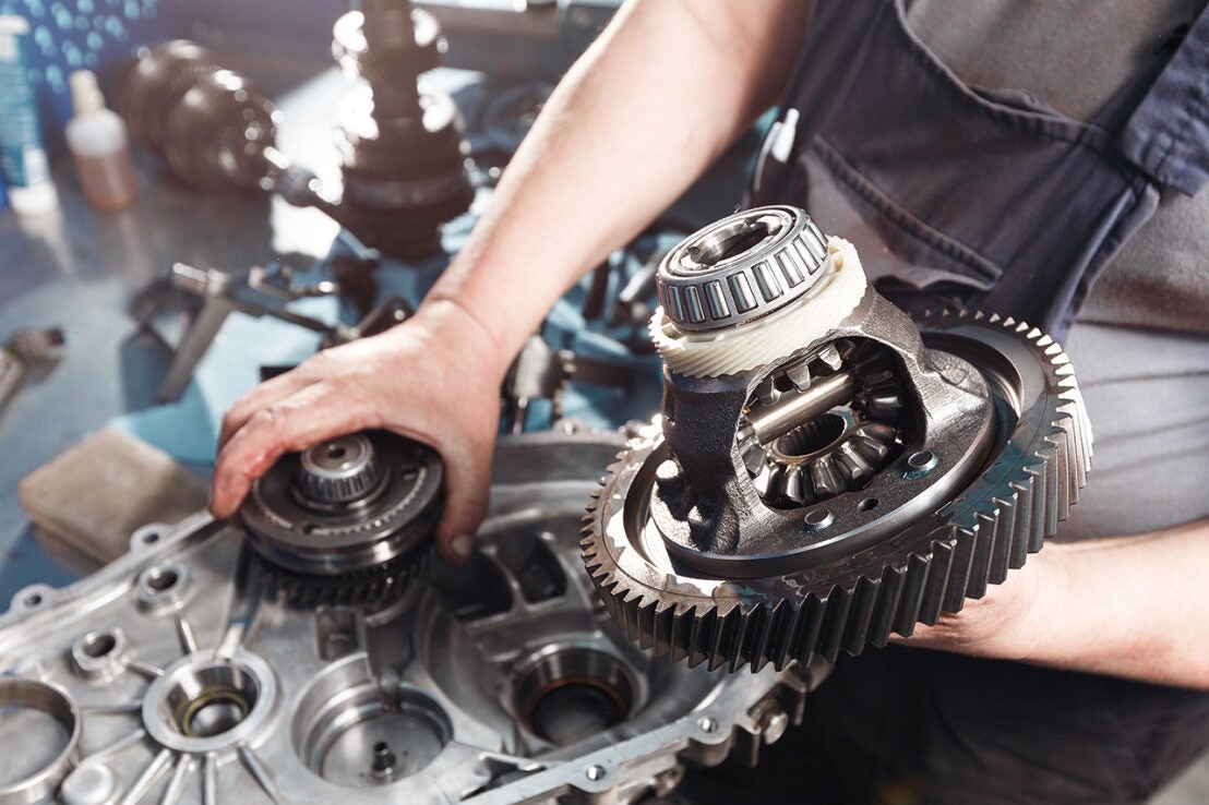 Cross-section of a car gearbox. mechanics work in the garage. hand mechanic in working clothes