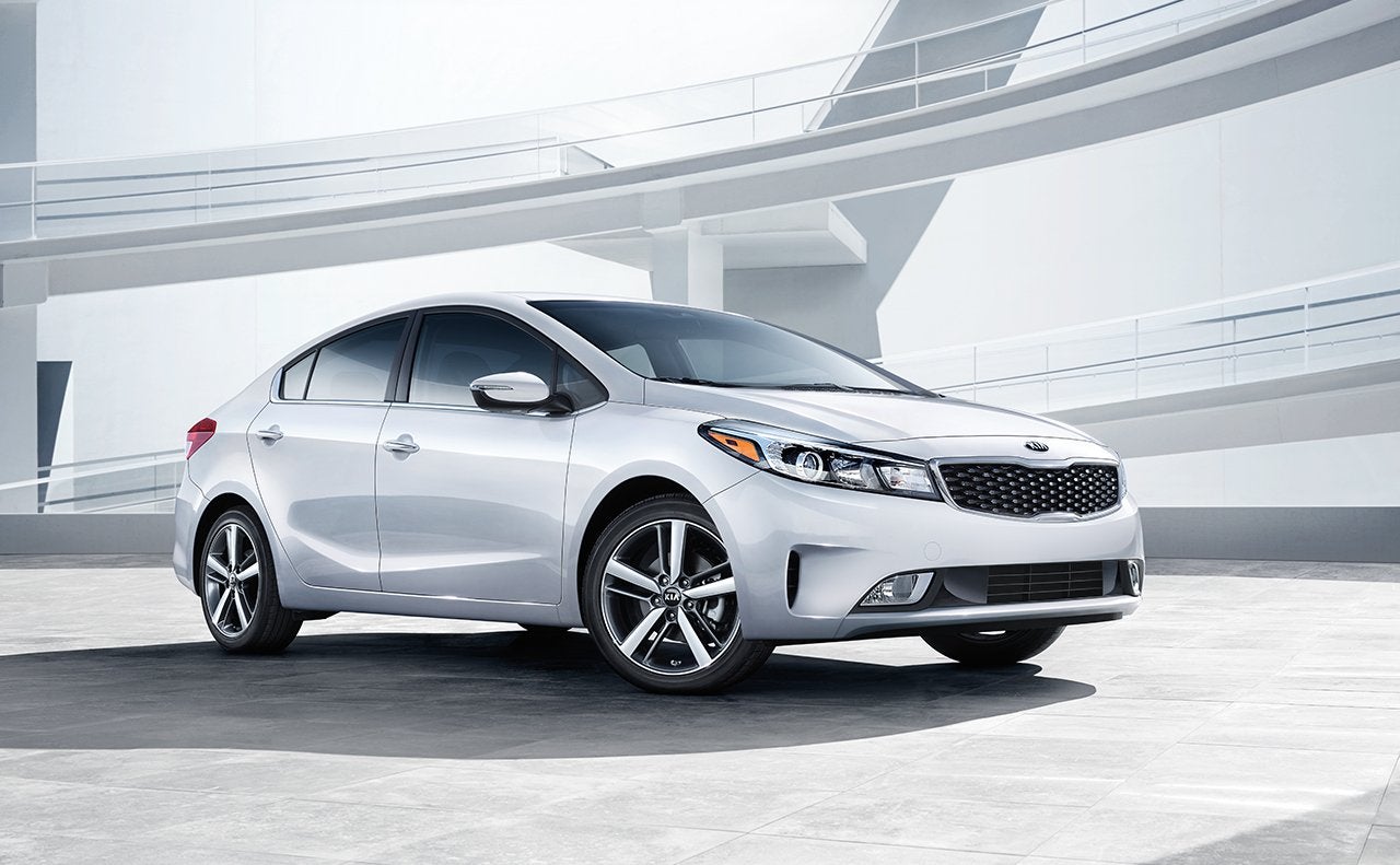 silver kia forte in front of a window