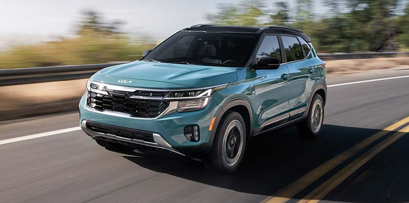 A blue 2026 Kia Seltos driving down the road.