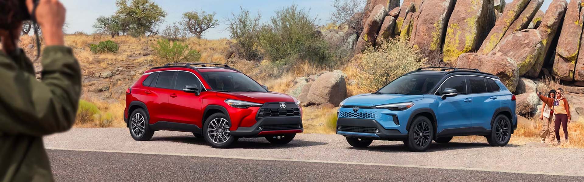 Red and blue Toyota SUVs parked in a desert landscape