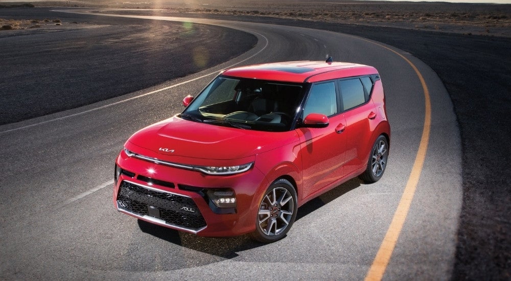 A red 2021 Kia Soul parked on a highway.