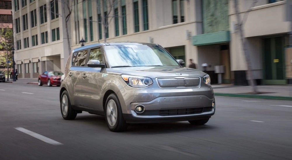A silver 2019 Kia Soul driving in a city.