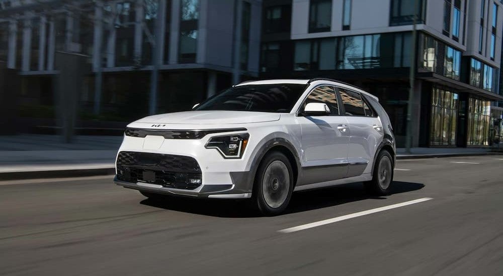 A white 2026 Kia Niro driving in a city.