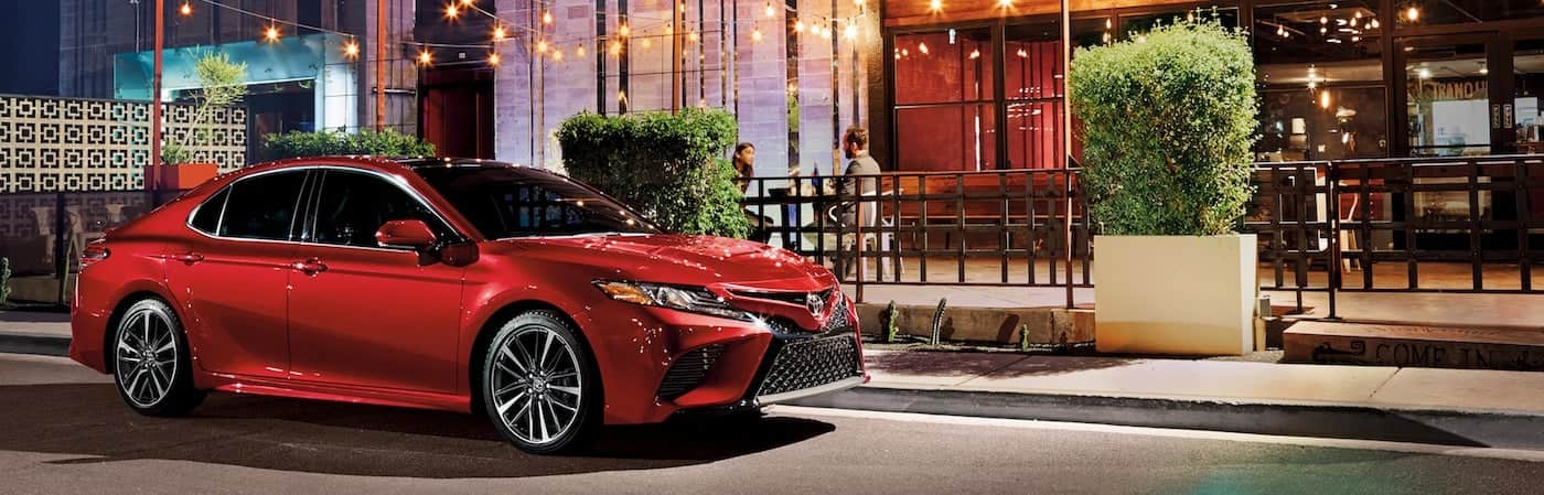A red 2019 Toyota Camry parked outside of a restaurant