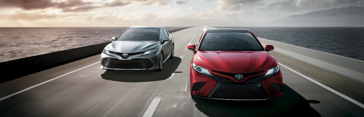 Two 2019 Toyota Camrys driving down an open road