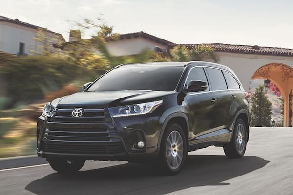 A black 2019 Toyota Highlander driving through the suburbs