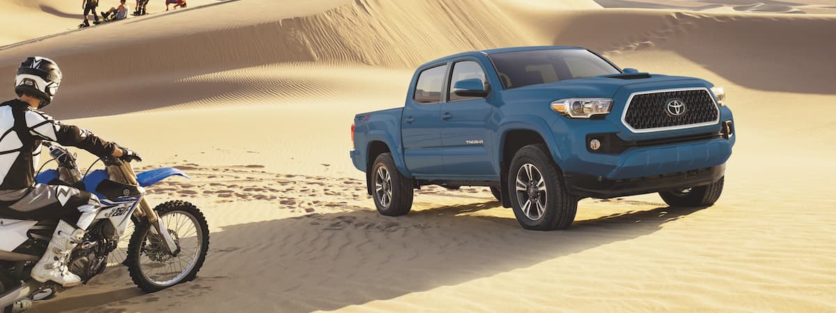 A blue 2019 Toyota Tacoma TRD Sport parked in sand dunes