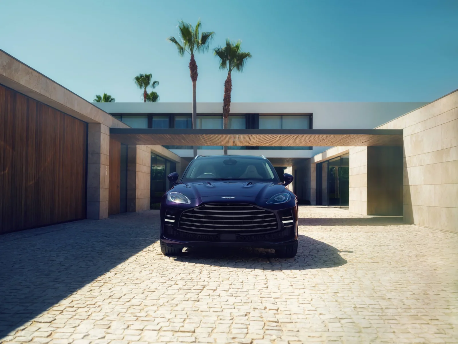 Aston Martin DBX GT front view parked in a modern courtyard