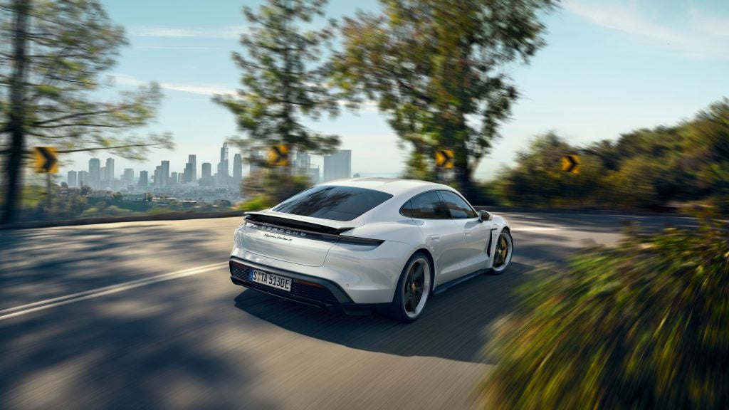 Porsche Taycan Turbo on the road driving away from the camera