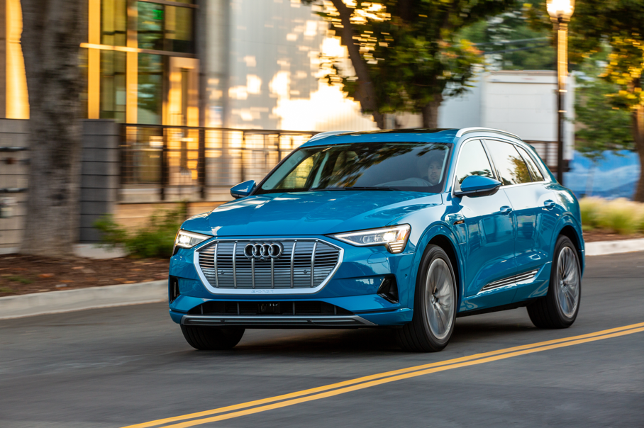 Audi e-tron 3/4 angle shot driving on an urban road.