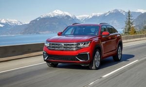 The 2021 Atlas Cross Sport driving with mountains behind it.