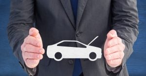 Businessman holding car safety symbol
