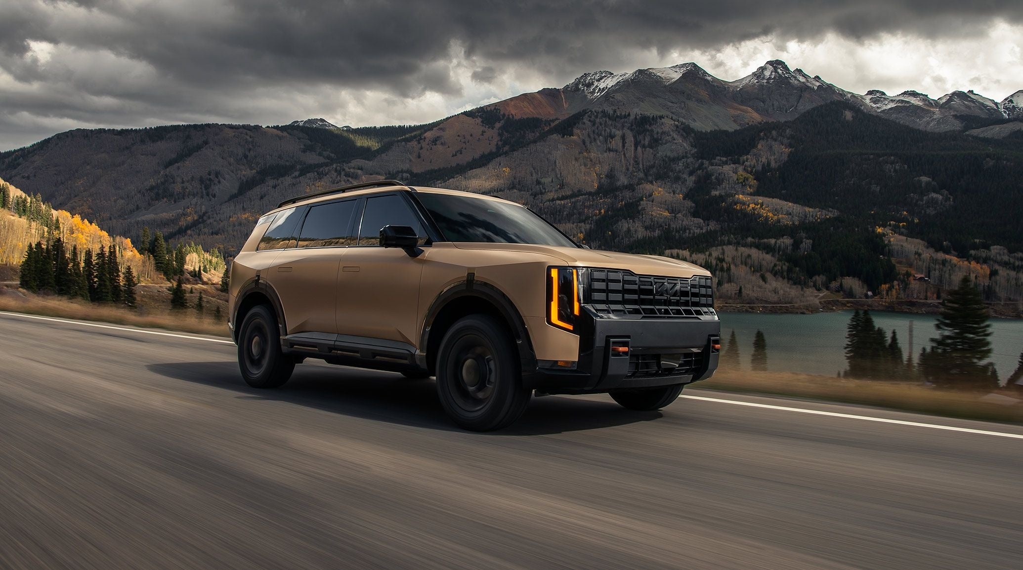 Tan 2027 Kia Telluride driving down a 